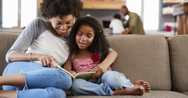 Mom and daughter on sofa of new home