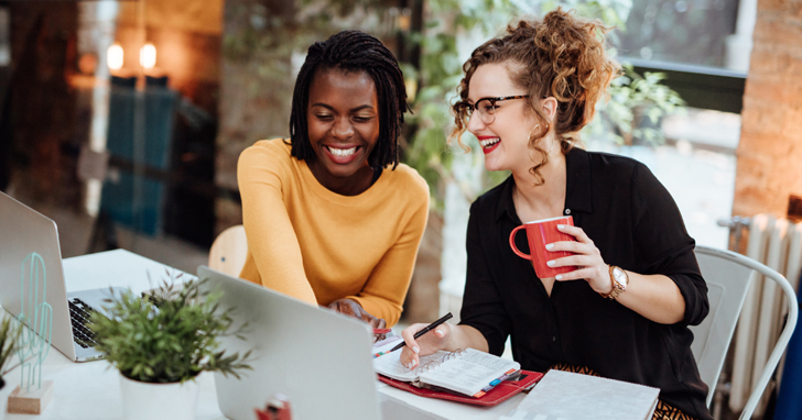 Two young women in front of laptop