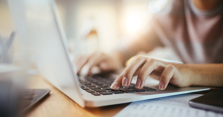 Fingers typing on laptop