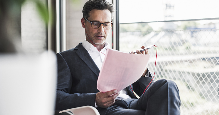 Man reviews paperwork by window